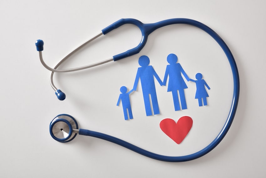 Stethoscope surrounding a paper cutout family – family medicine concept